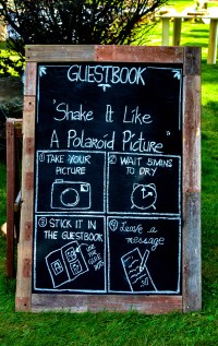 Wooden guestbook sign written by hand in chalk