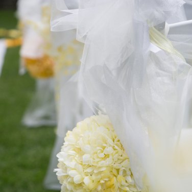 Yellow flowers and white ribbons aisle decorations