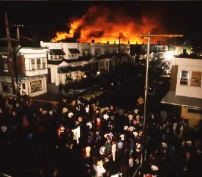 A crowd gathers to watch the conflagration, which had consumed the entire 6200 block of Osage Avenue in a Black middle-class neighborhood by the time the firefighters were told to aim their hoses at it.