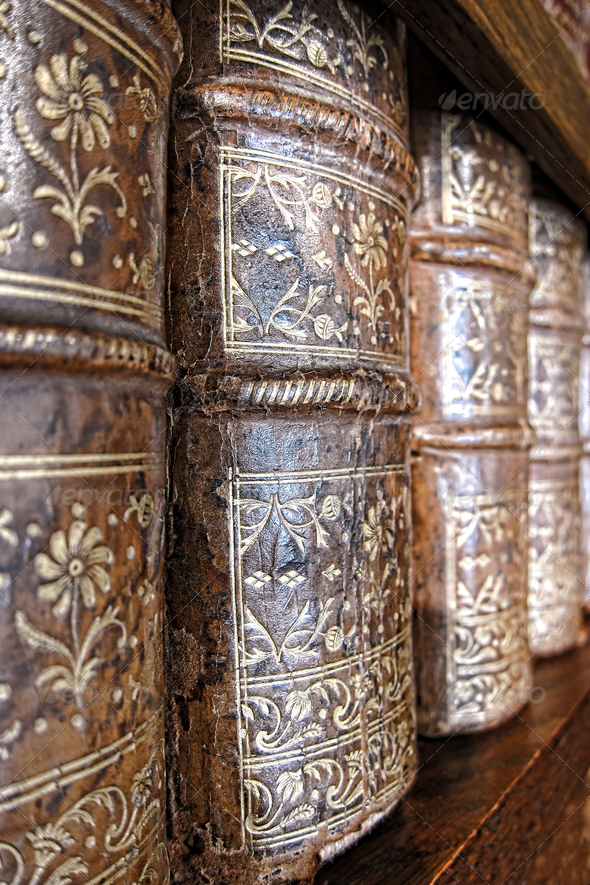 Old and worn leather cover bound books spine with aged gold leaf