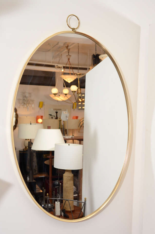 1960s Graceful Oval Brass Mirror with Finial Detail For Sale at 1stdibs