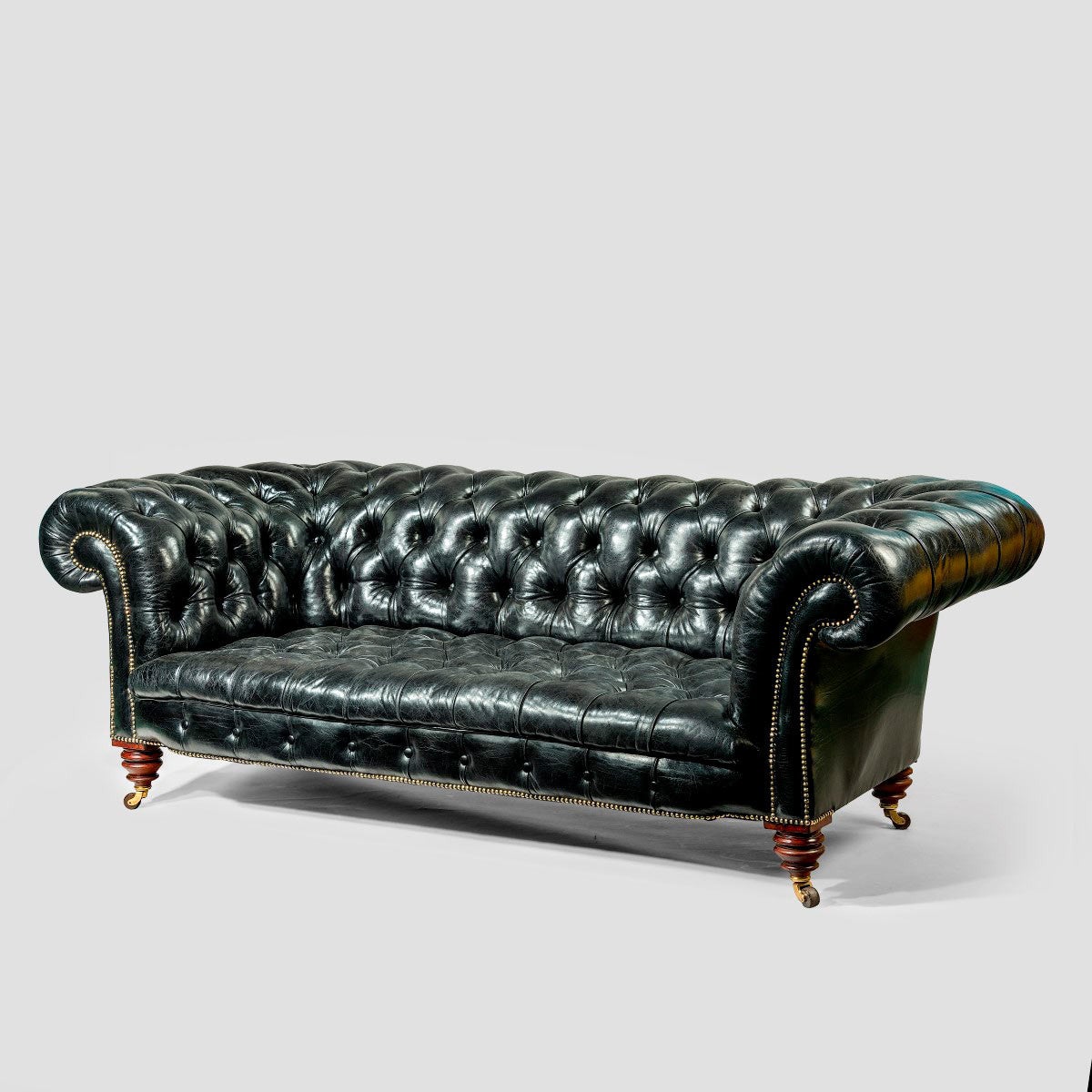 A pair of black leather Chesterfield sofas by Shoolbred at 1stDibs