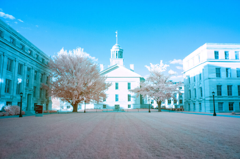 Side shot of Iowa Old State Capital with pink grass and blue tinted buildings