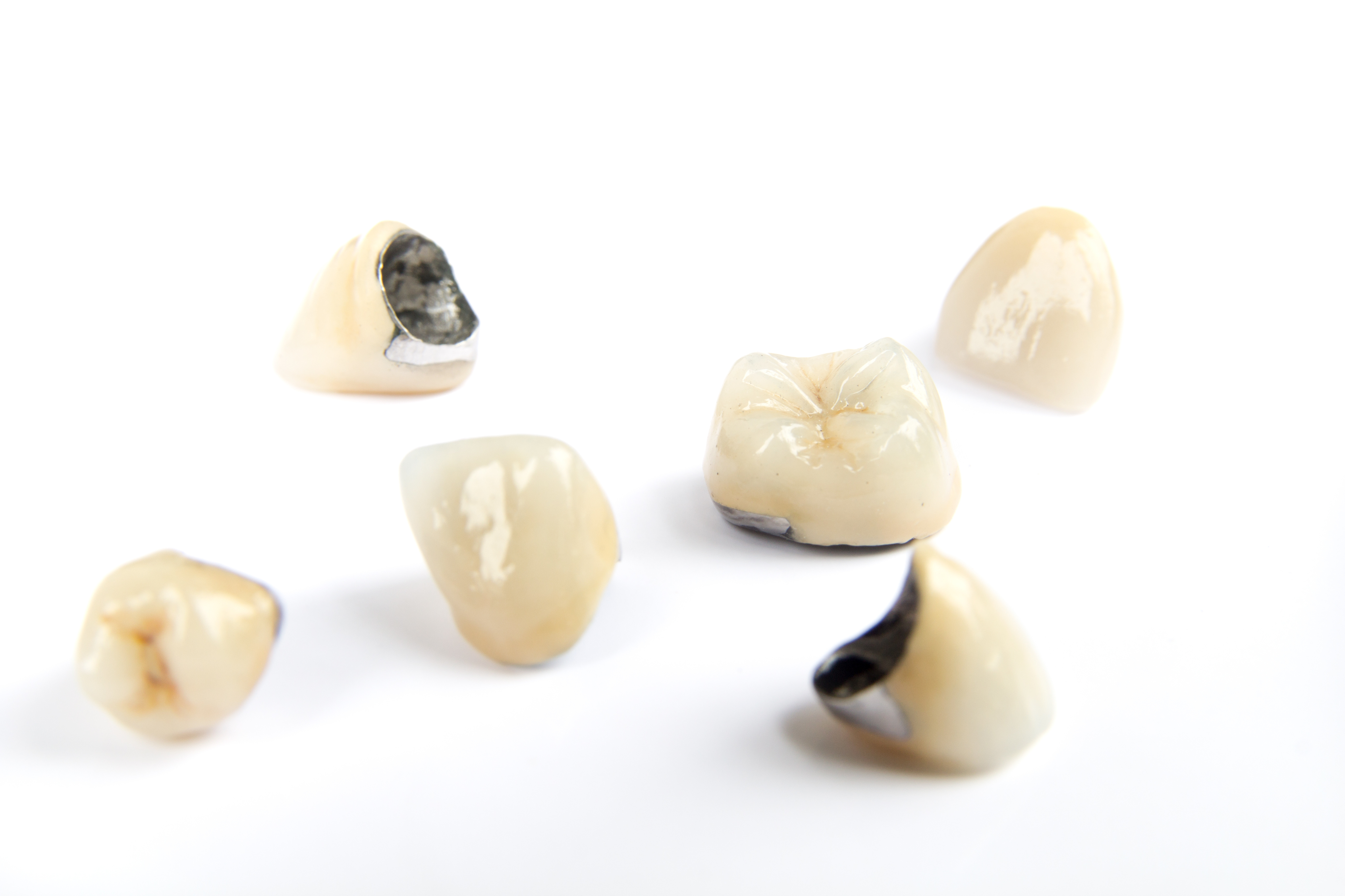 Dental ceramic tooth crowns on white background. Isolated. ABQ Dental