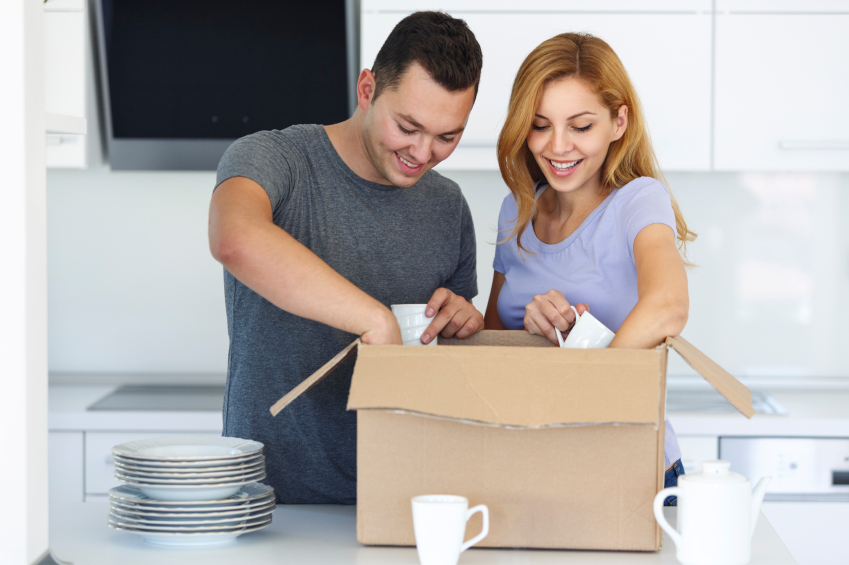 Young couple unpacking boxes in kitchen Admiral Movers