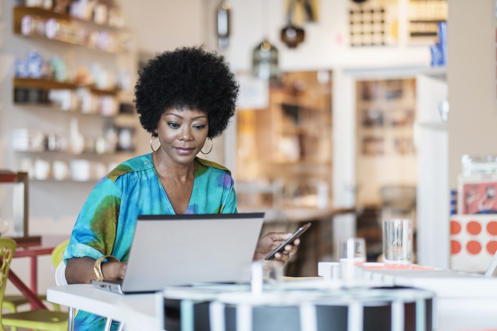 African American business owner using laptop in store AFRO American
