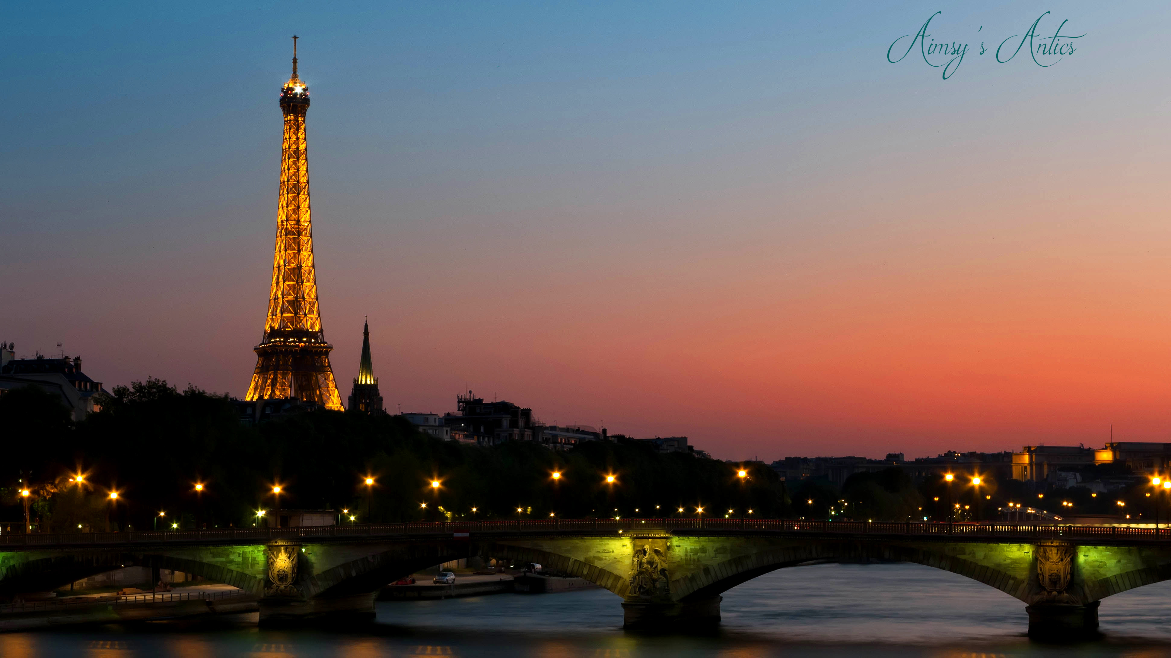 Night view of Paris, with the Eiffel Tower lit up with lights. 