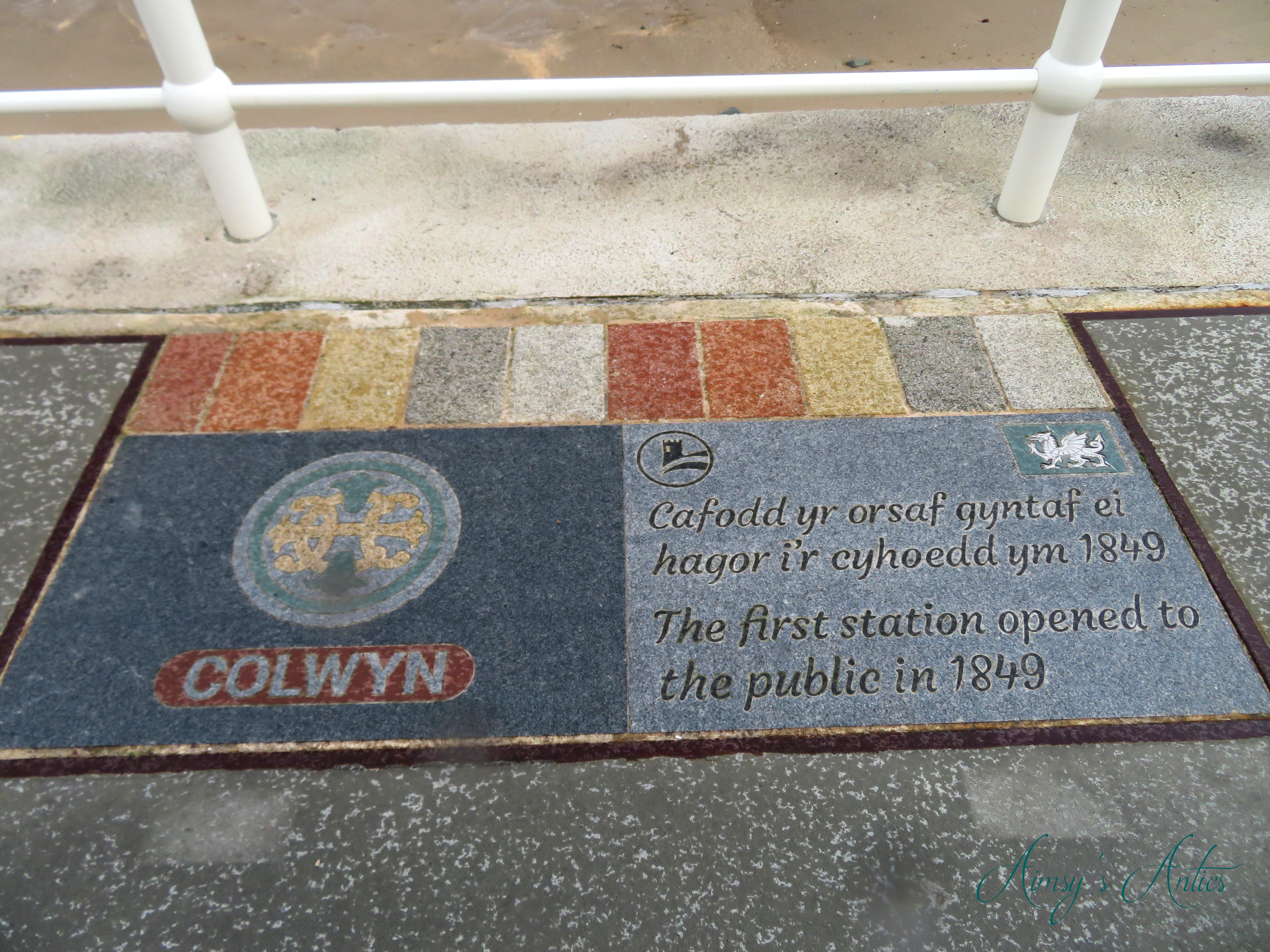 A floor sign in Colwyn Bay detailing when the first train station opened.