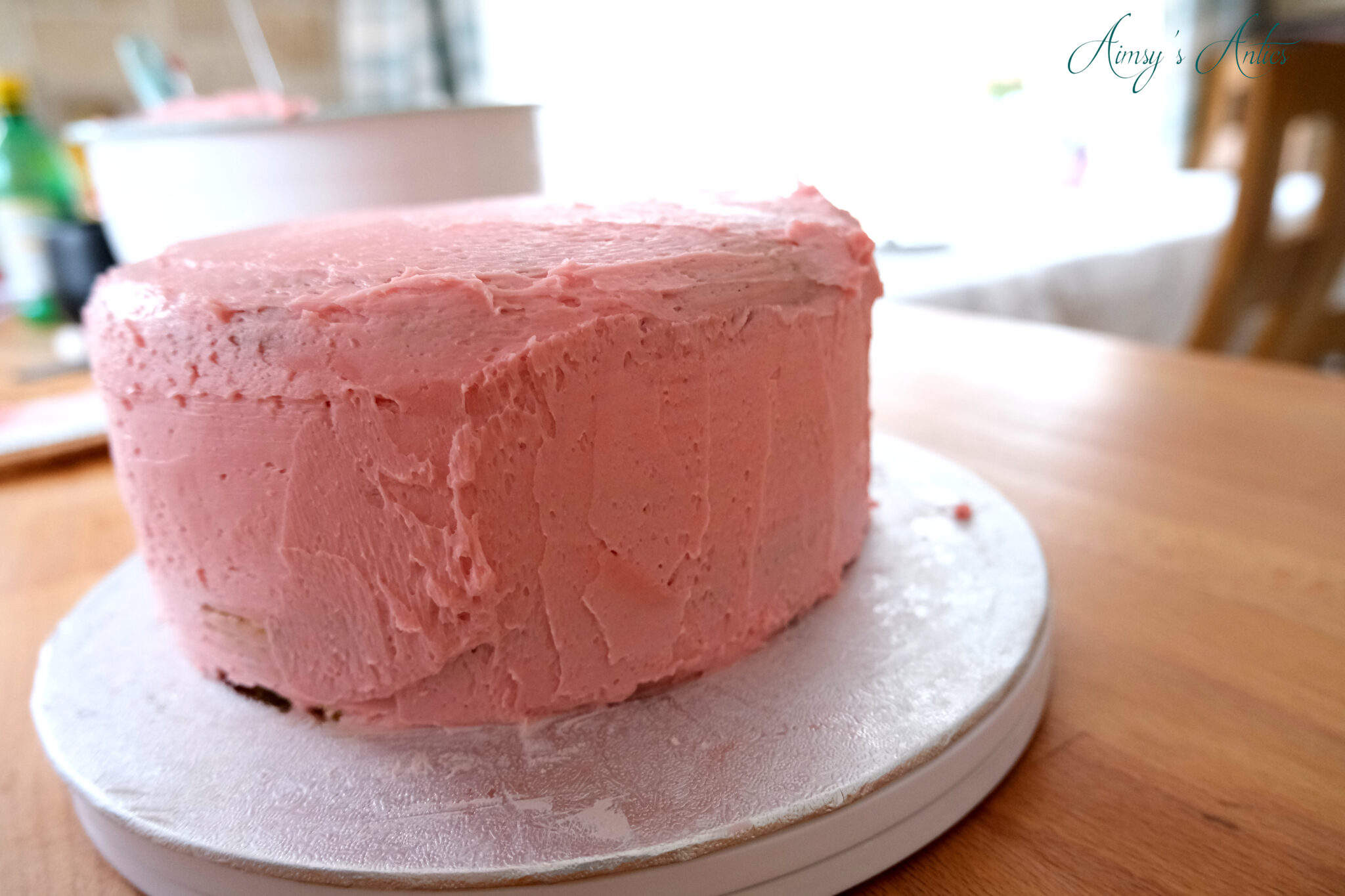 Adding on the buttercream frosting to the pistachio and rose cake