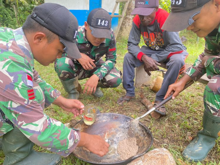 Satgas Yonif 143/TWEJ Ajarkan Masyarakat Cara Membuat Minyak Kelapa
