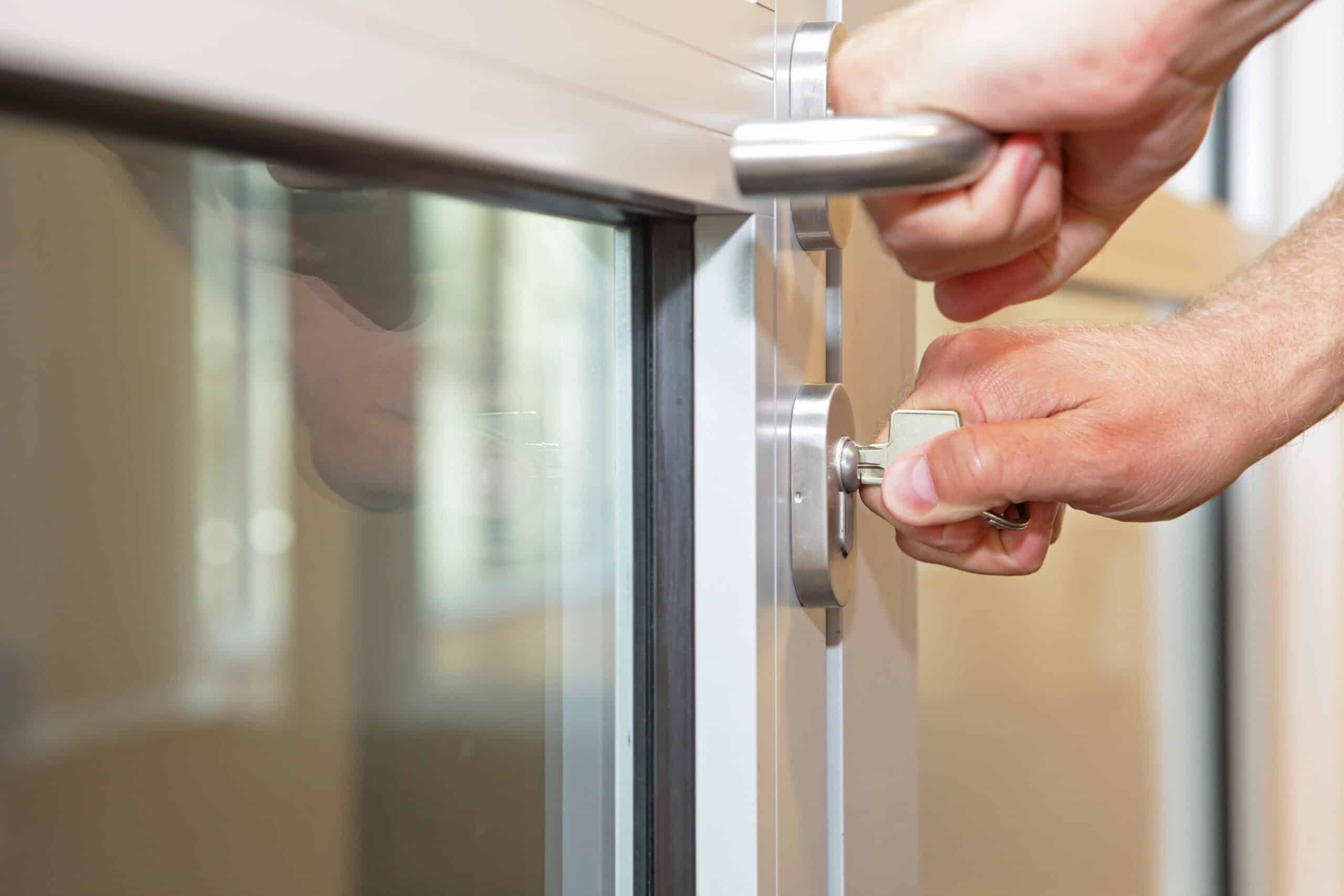 hands opening locked door with typical key close up All Locksmith