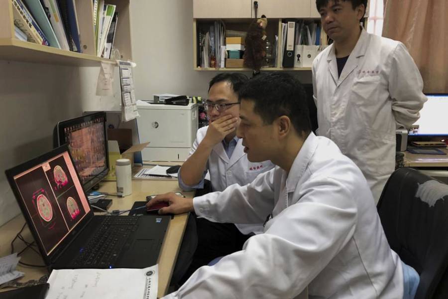 Doctors Huddle Around Computer