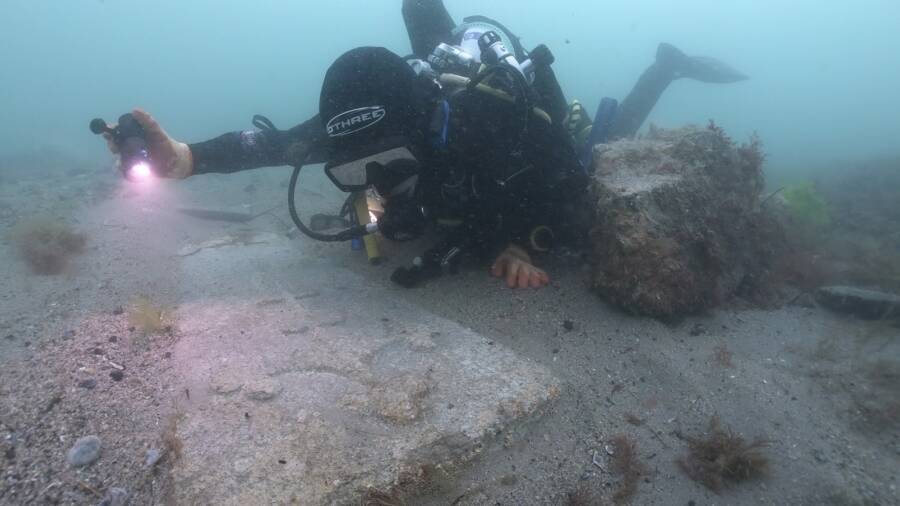 Diver Examining Marble Gravestone