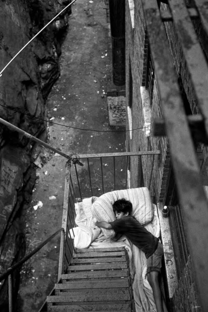 Child Sleeping On A Fire Escape