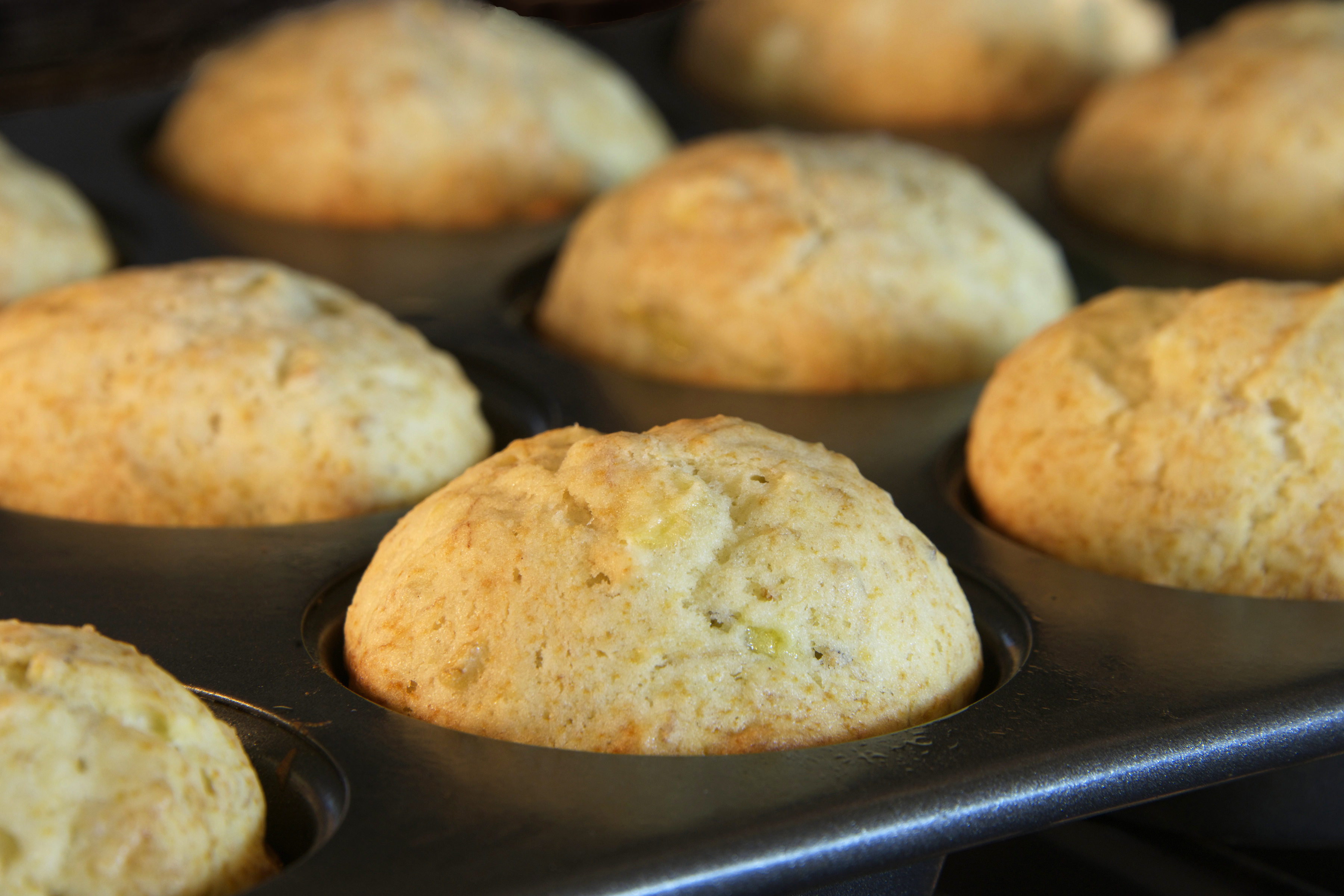 Banana bread muffins baking in a convection oven. Golden brown almost