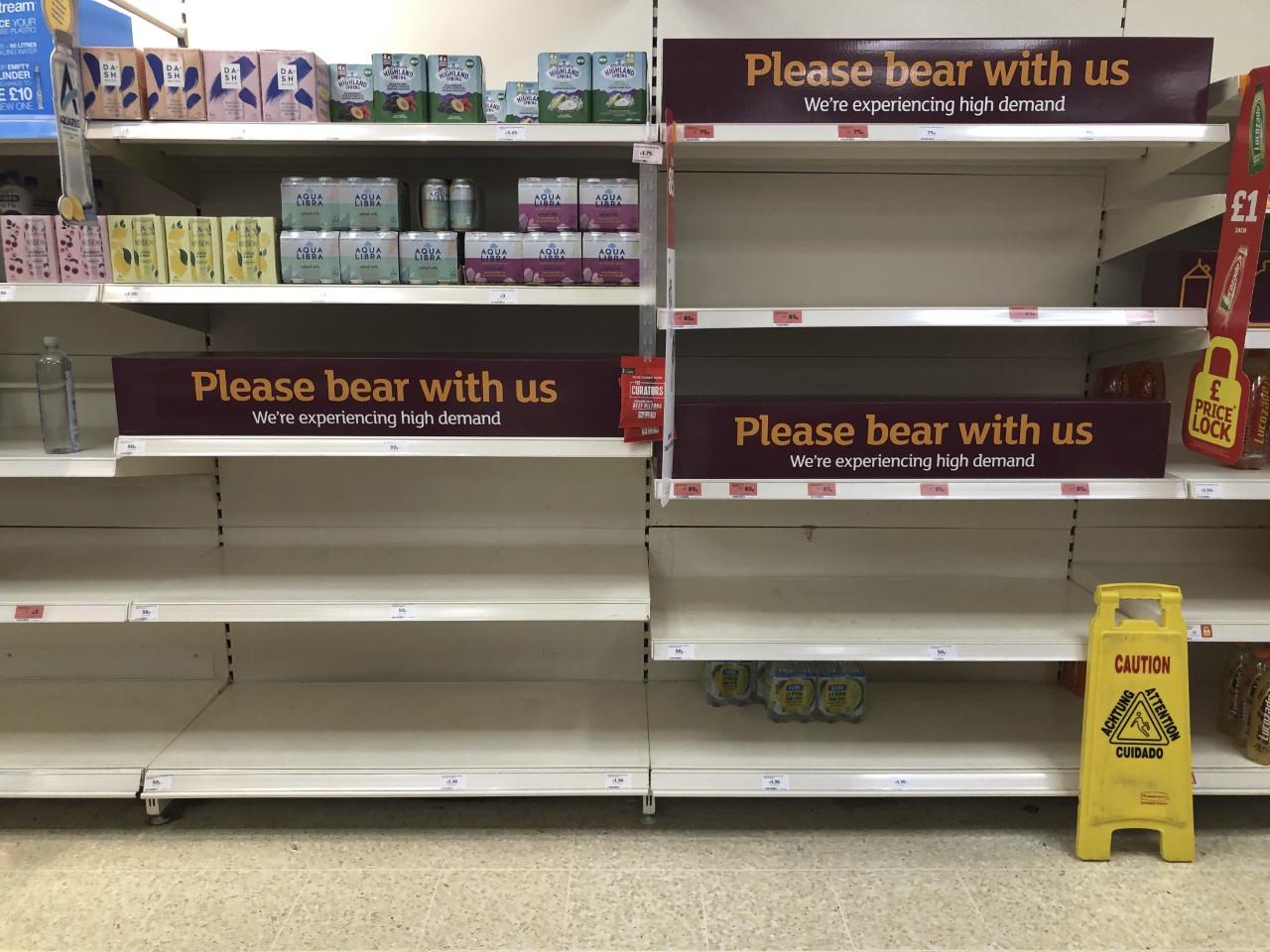 Empty shelves and signs on the soft drinks aisle of a Sainsbury's store
