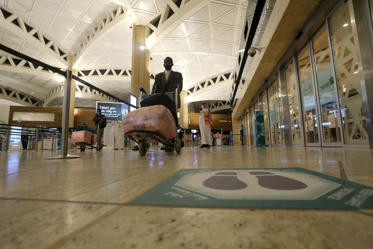 A social distancing sign is seen on the floor as a Saudi man man