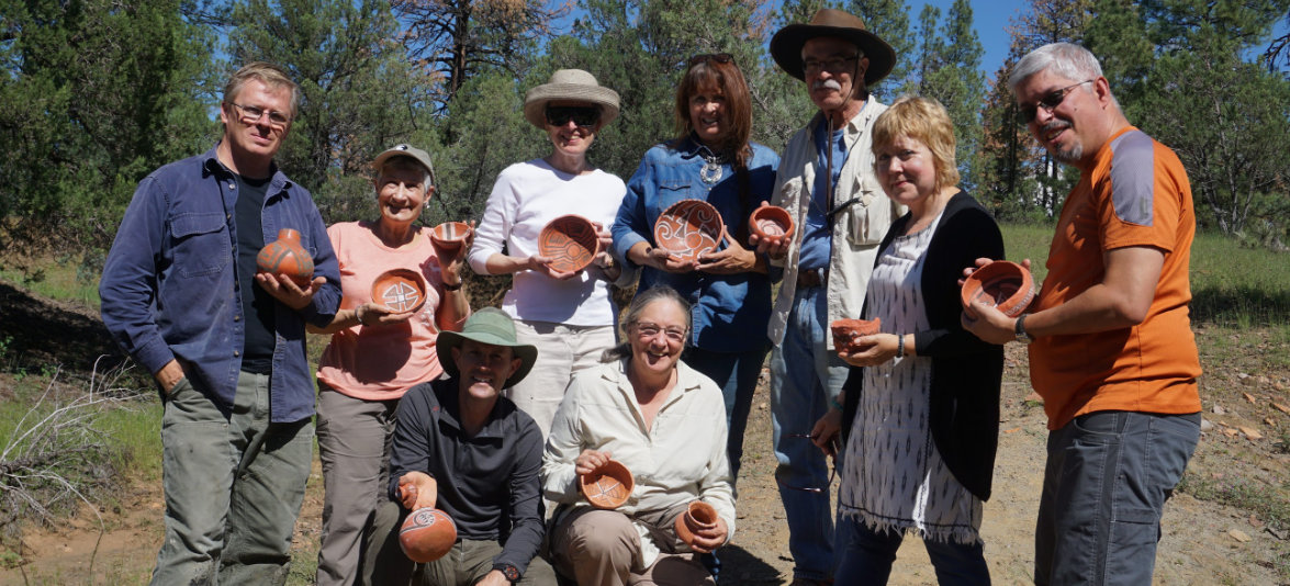 A class showing off their finished coiled pottery