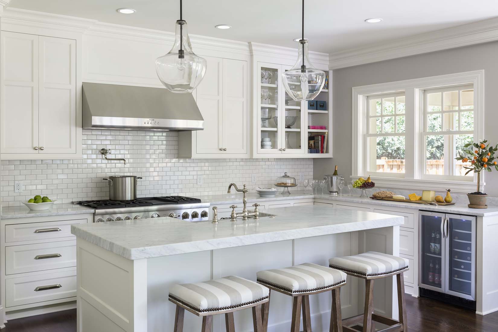 Upscale white kitchen with large island and marble countertops Andrea