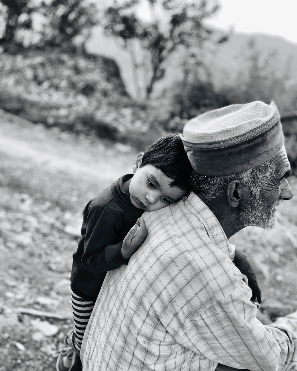 boy leaning beside an old man