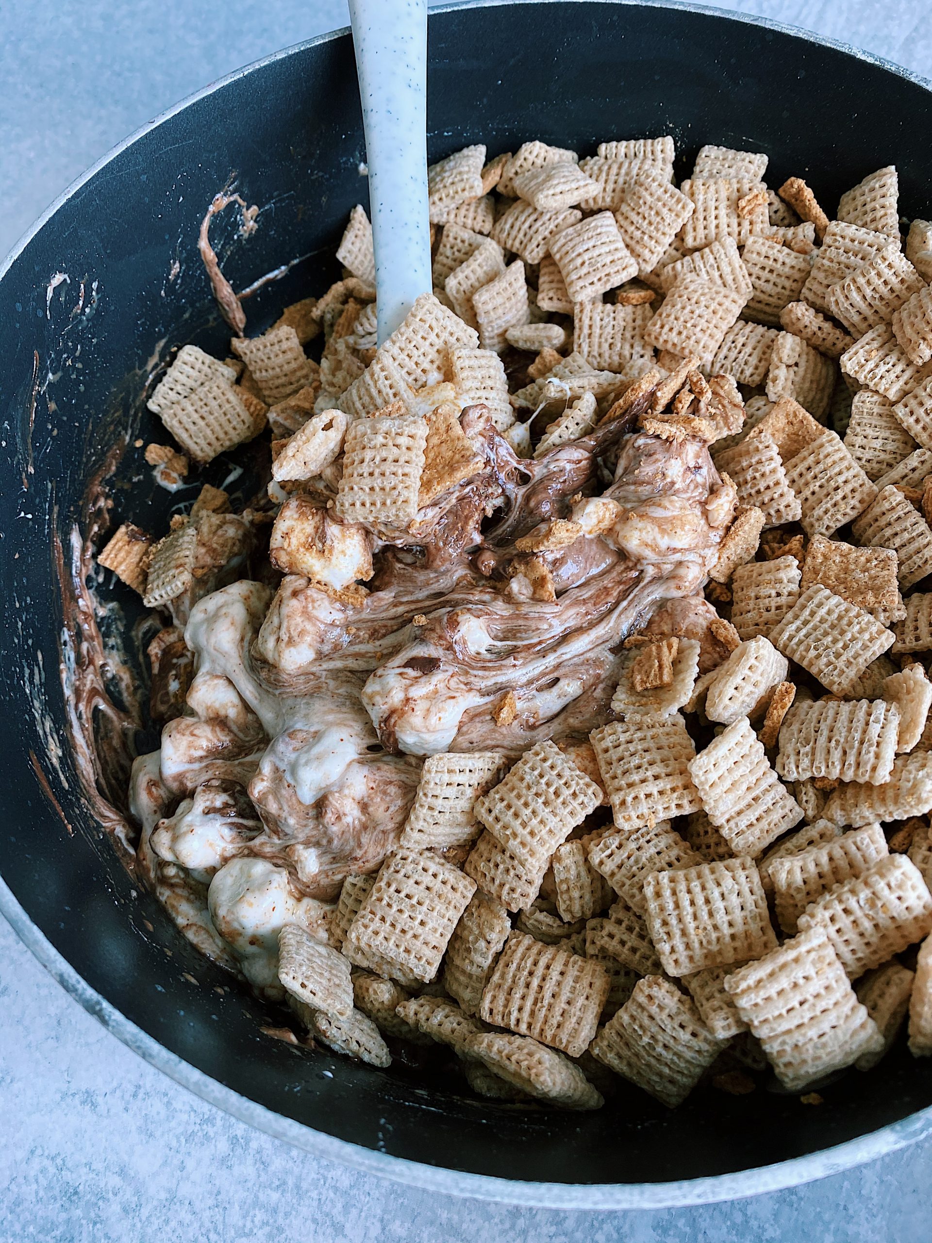 chex added to marshmallow mixture for S'mores Puppy Chow in sauce pot.