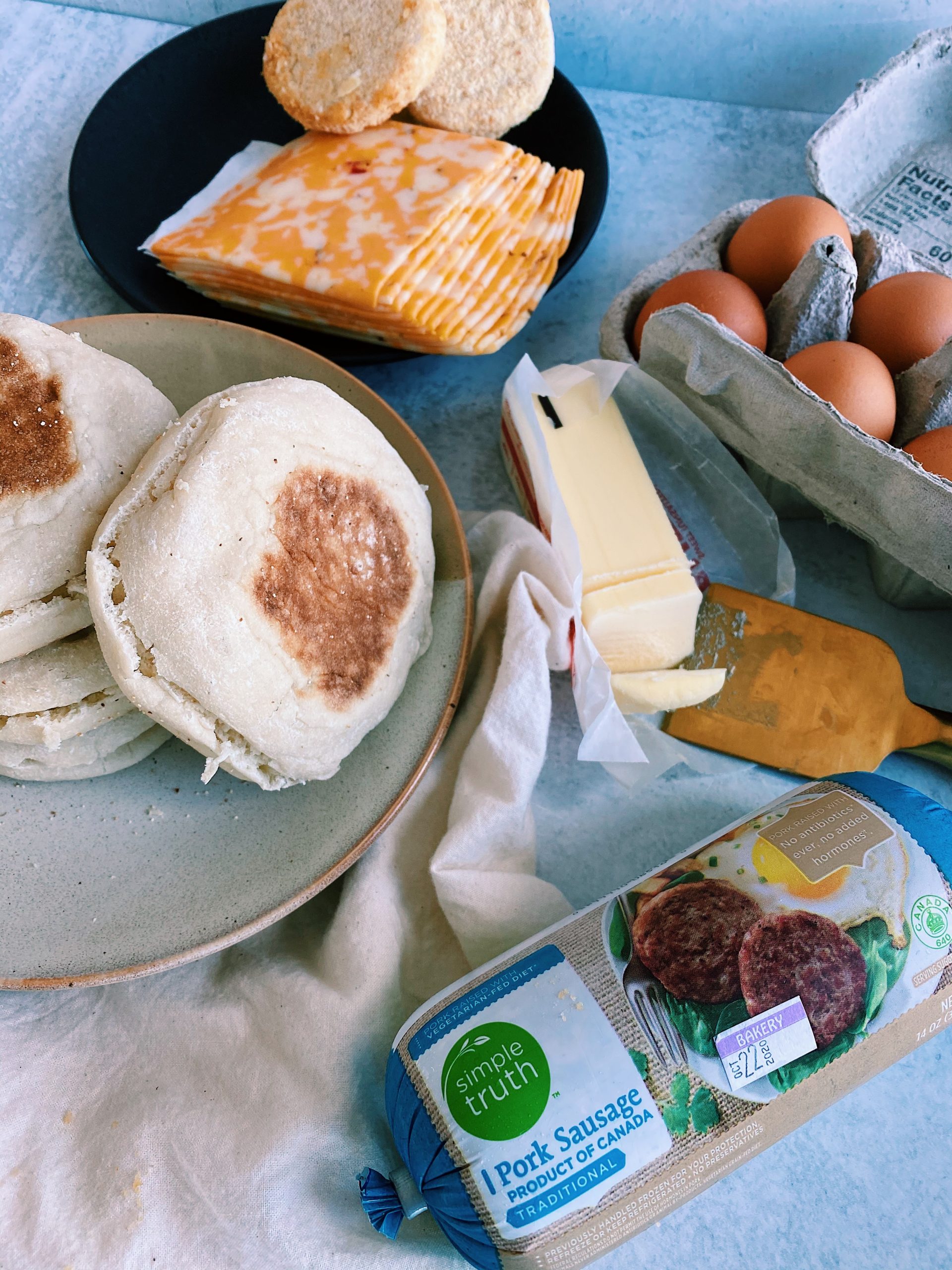 Flat lay of mcmuffin ingredients on concrete board.