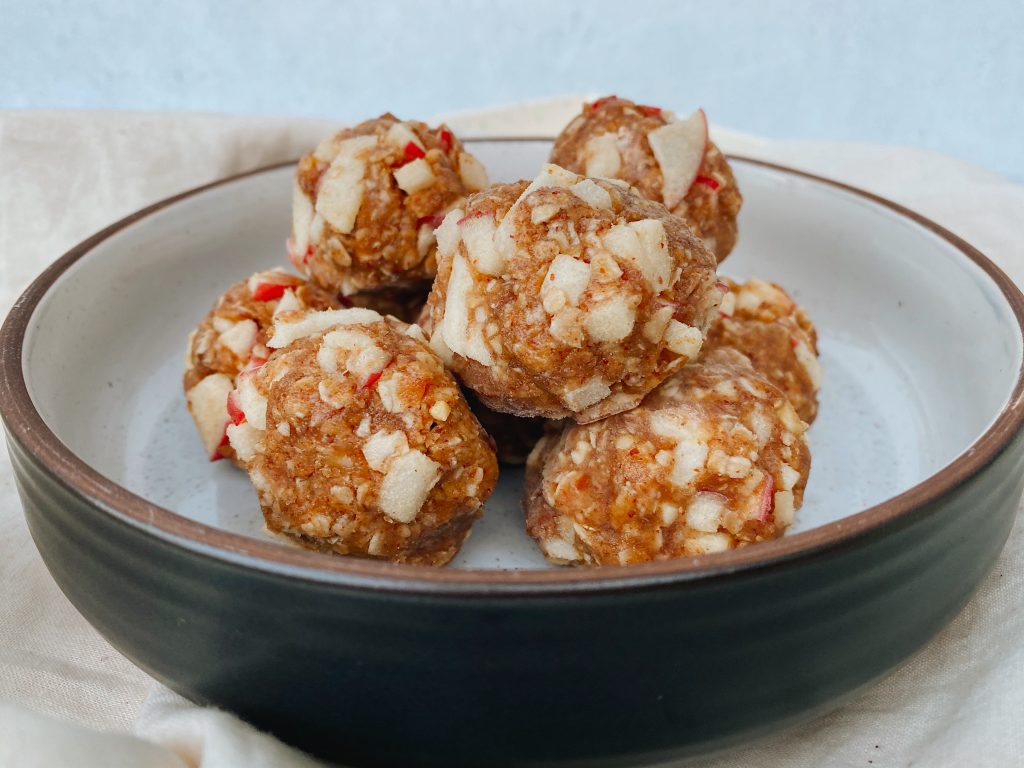 final energy bites stacked together in a circle array and white ceramic background with cloth