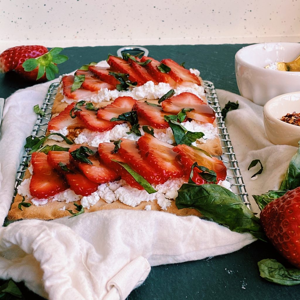 45 degree angle image of assembled crispbreads toped with basil leaves strawberry and balsamic glaze