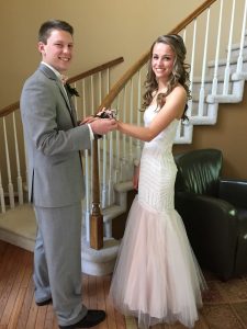 boy and girl in prom attire putting on the corsage