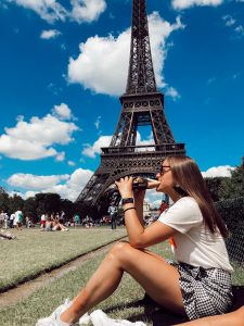 girl eating baguette in front of Eiffel Tower