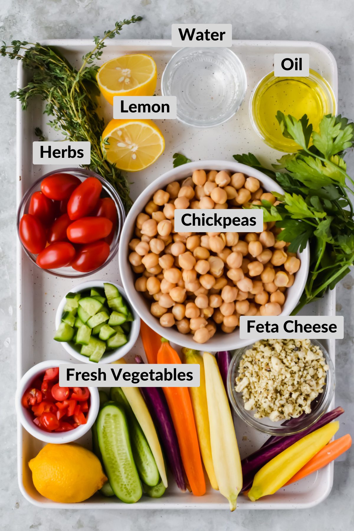 blender hummus ingredients in individual bowls on white baking tray.