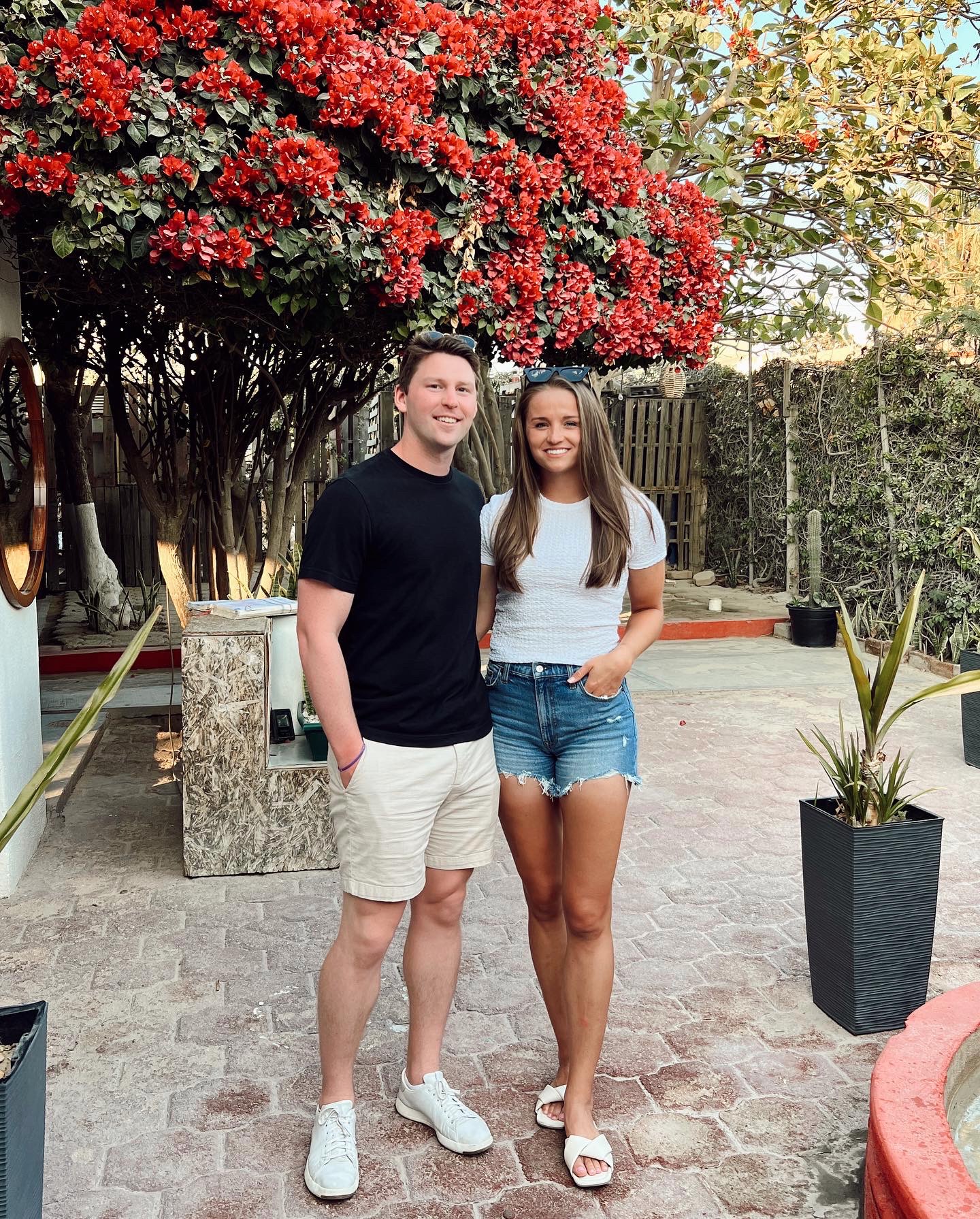 courtney and jack standing in front of a beautiful pink tree before dinner. 