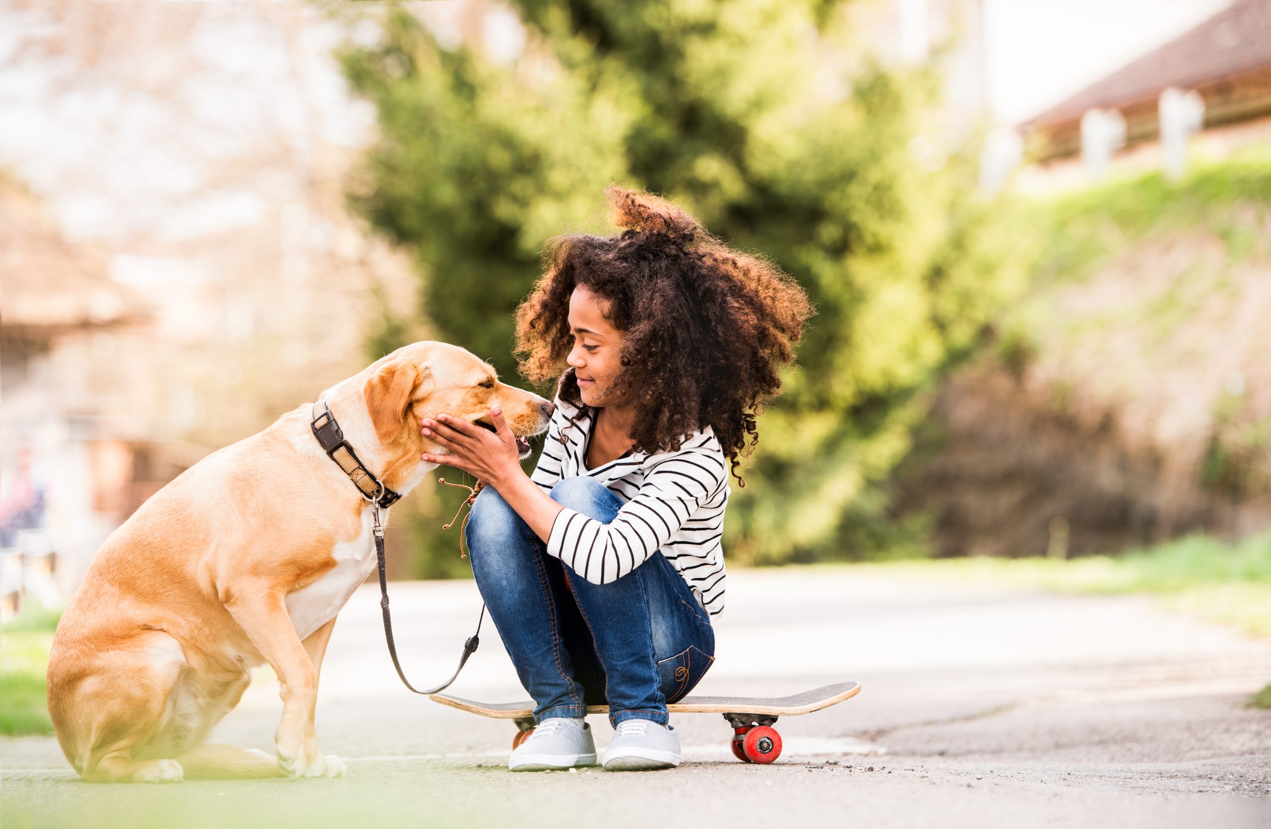 African american girl outdoors on skateboard with her dog