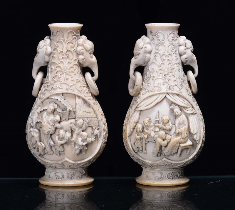 A pair of ivory vases with handles in the shape of elephant and