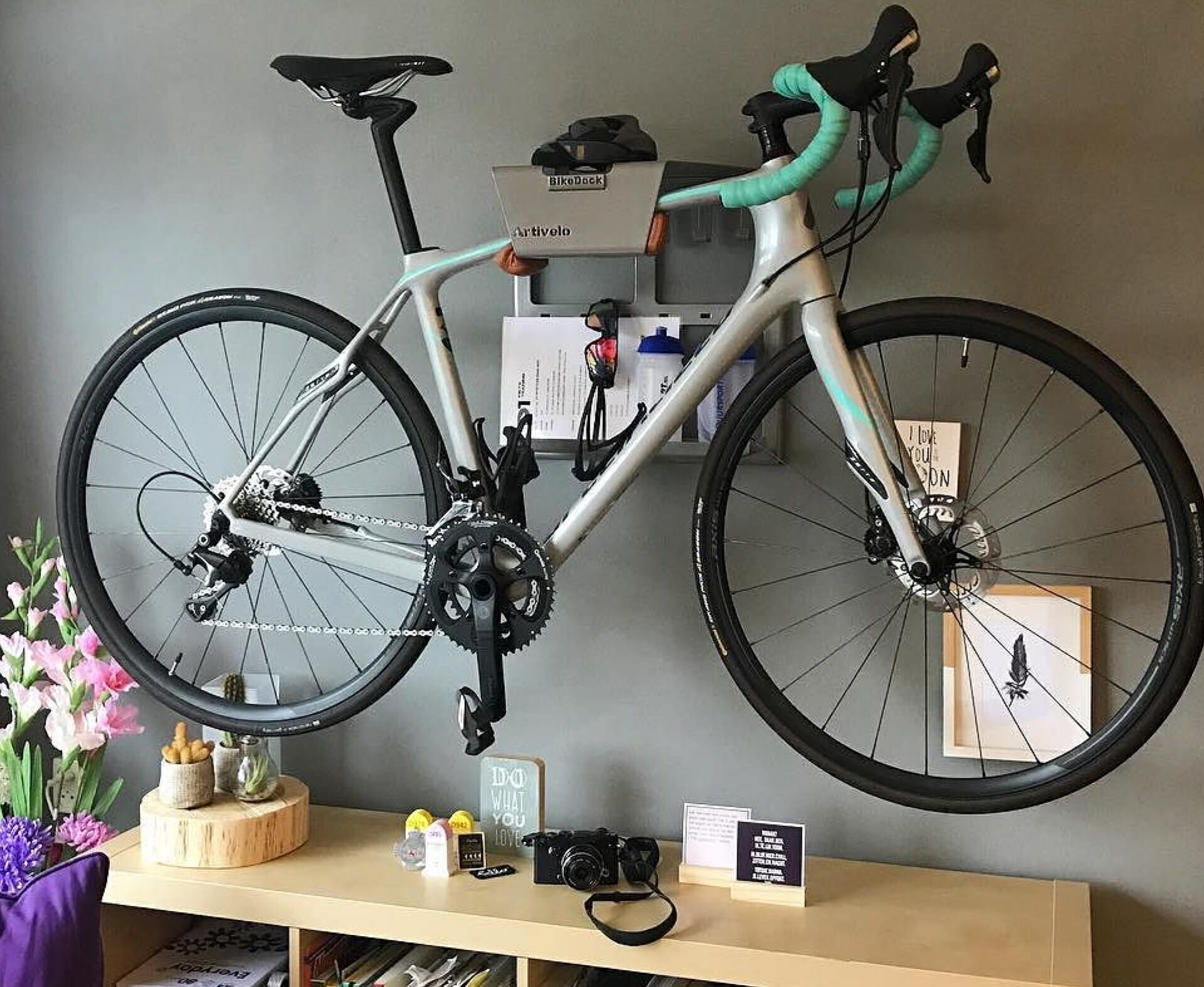 Grey road bike hanging system on the wall like Linda Artivelo English