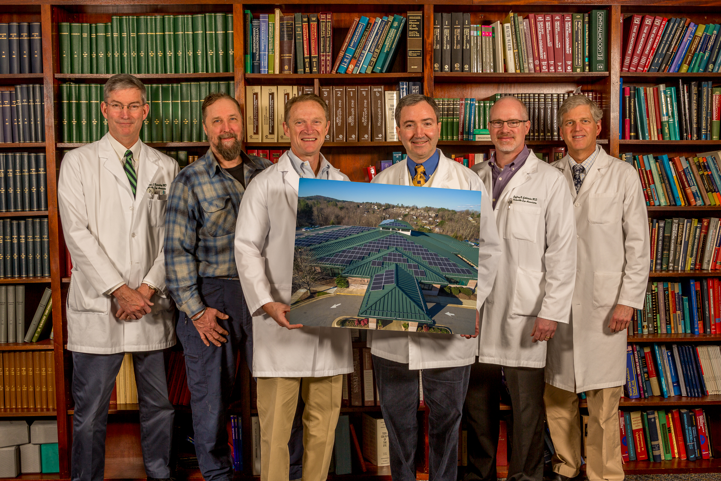 Doctors pose with photo of rooftop panels Asheville Eye