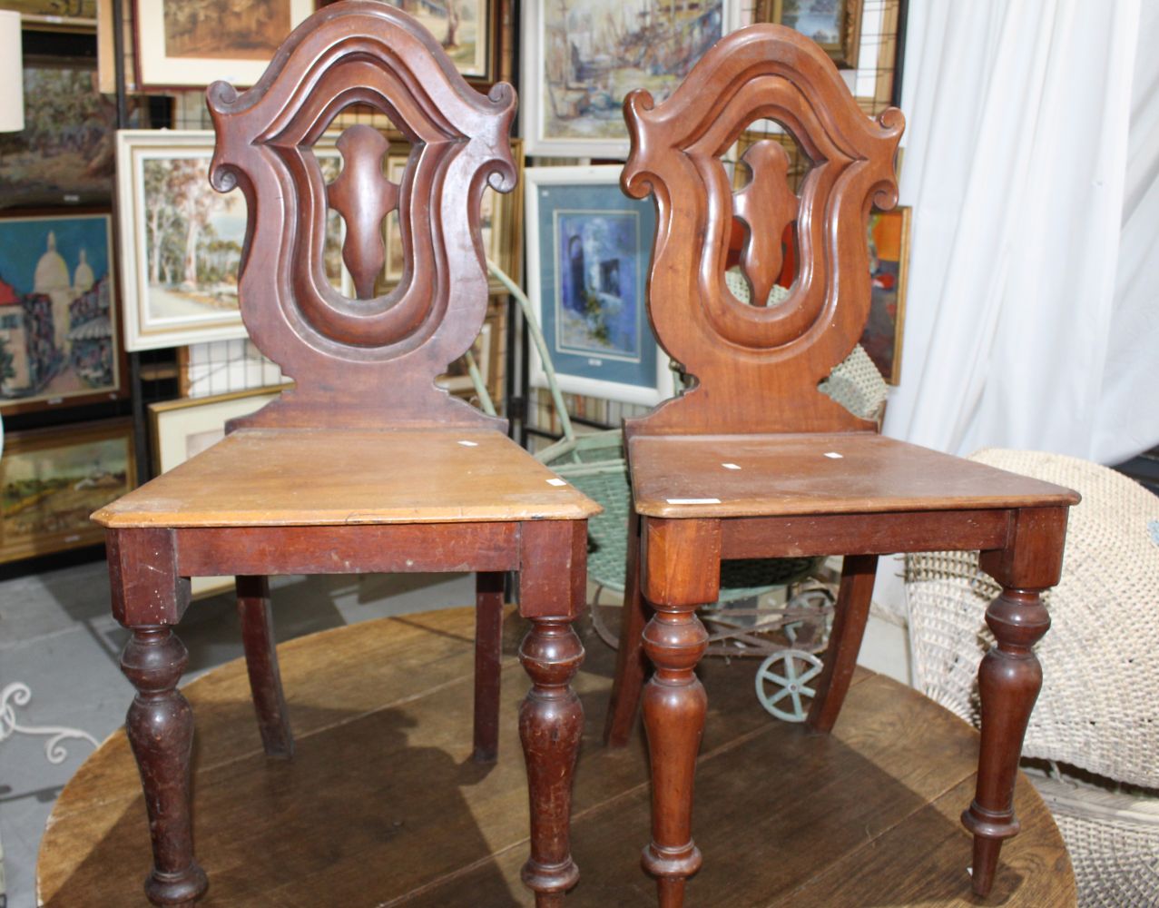 Pair of antique mahogany hall chairs with matching carved shield form