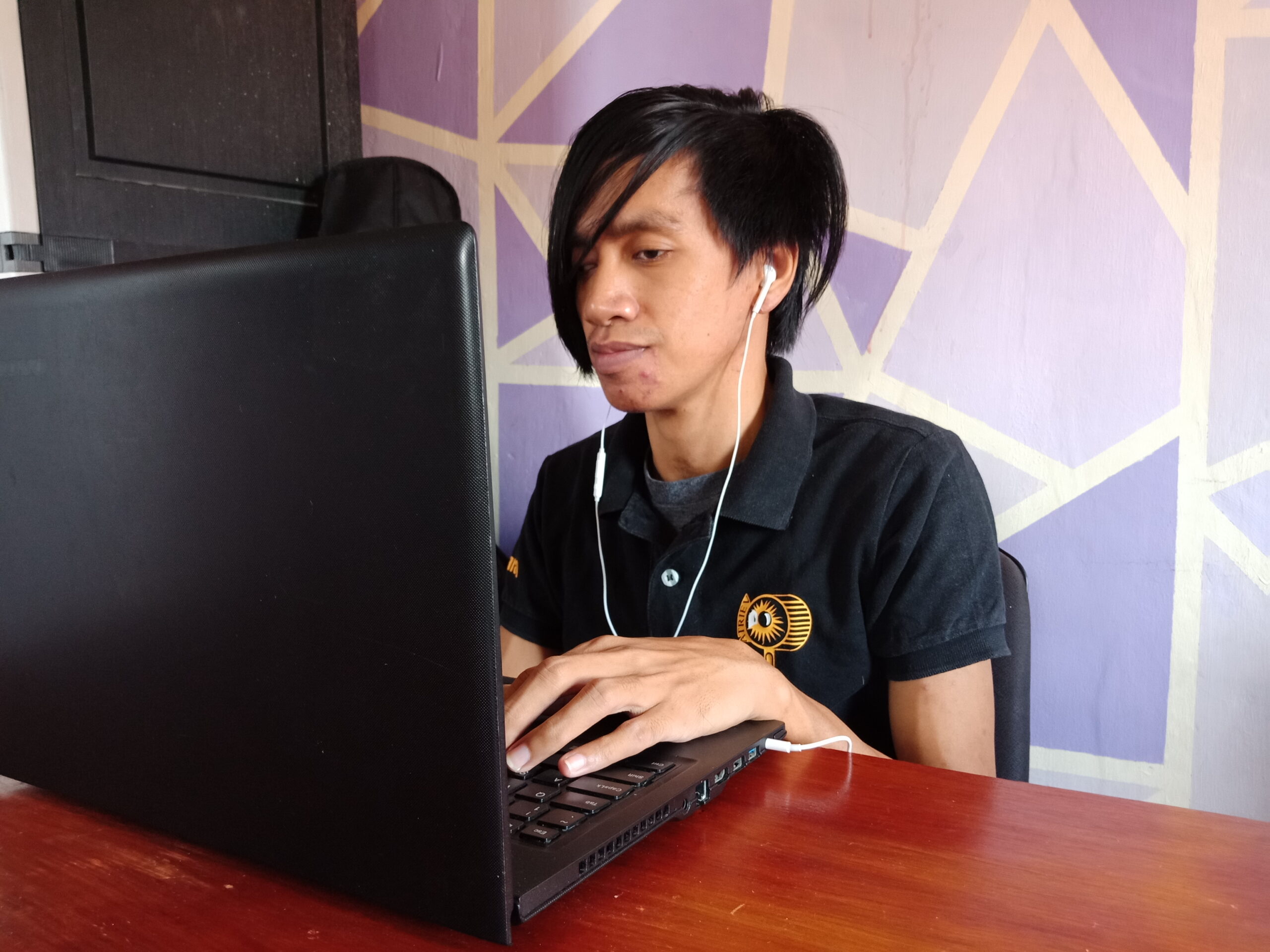 Rafael Sitting in front of his computer with hands on the keyboard