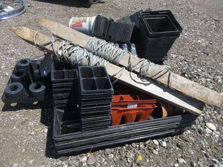 Garden stakes with twine, two stacks of garden seed flats with inserts