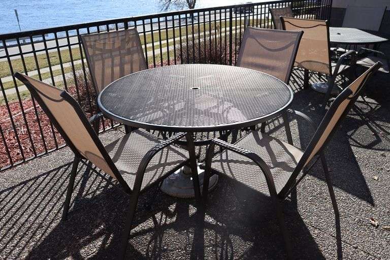 48" round expanded metal patio table with 4 tan chairs Backes Commercial Auctioneers