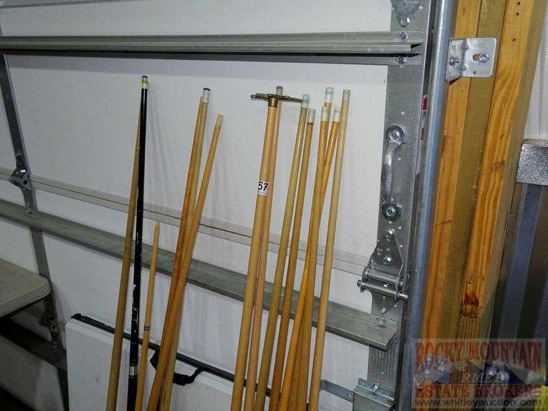 Lots of assorted pool cues, bridge & wall mount pool cue holder. All