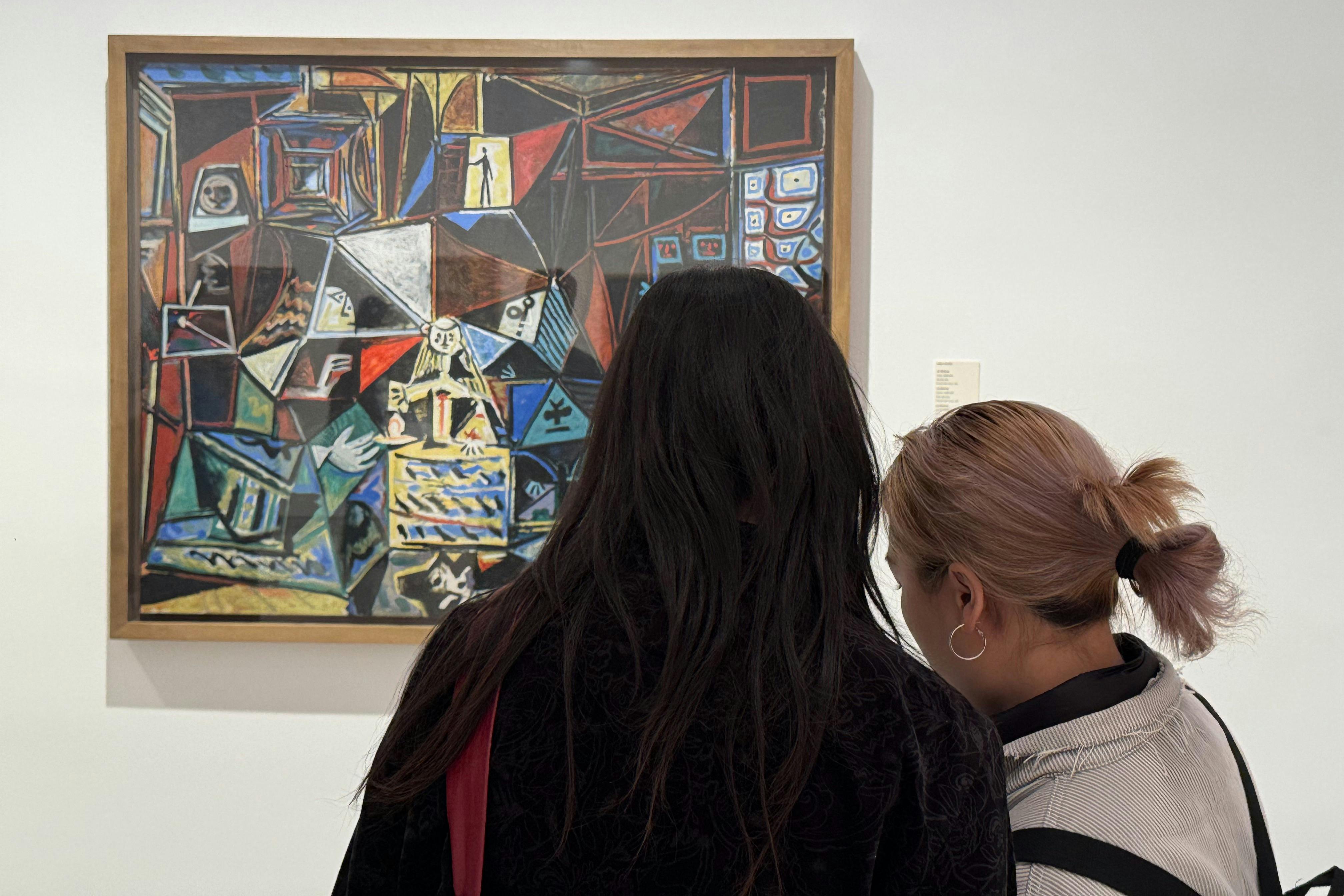 Two visitors closely examine one of Picasso’s cubist reinterpretations of Las Meninas, with its bold geometric shapes.