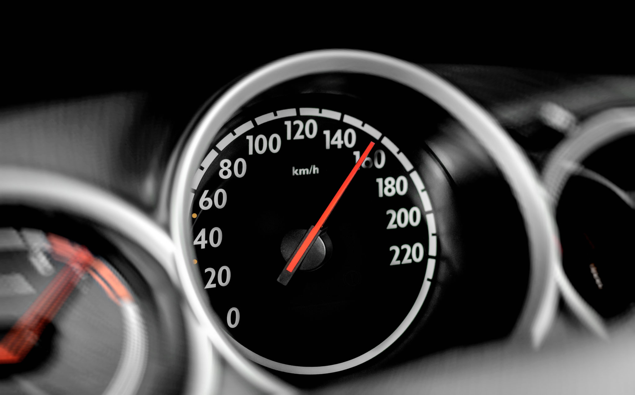 High speed on a car speedometer and motion blur. Babcox Media