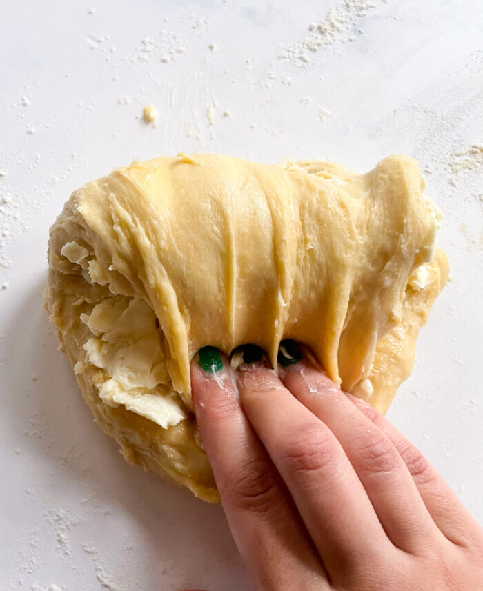 kneading soft butter into the dough