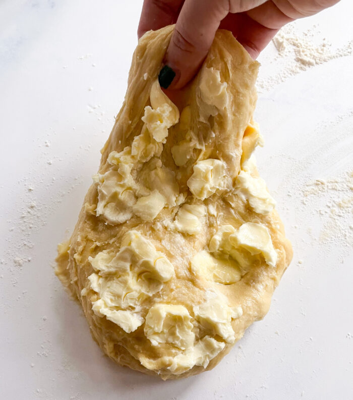 kneading soft butter into the dough