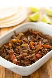 Beef fajitas on a white plate.