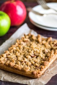 Apple pie bars on parchment paper before being cut.