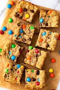 Monster cookie bars stacked on a white plate.