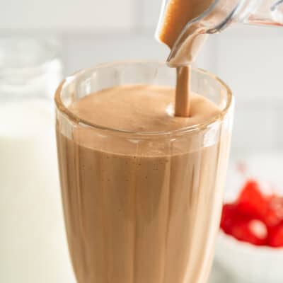 Chocolate malted milkshake being poured into a glass.