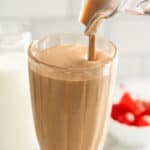 Chocolate malted milkshake being poured into a glass.